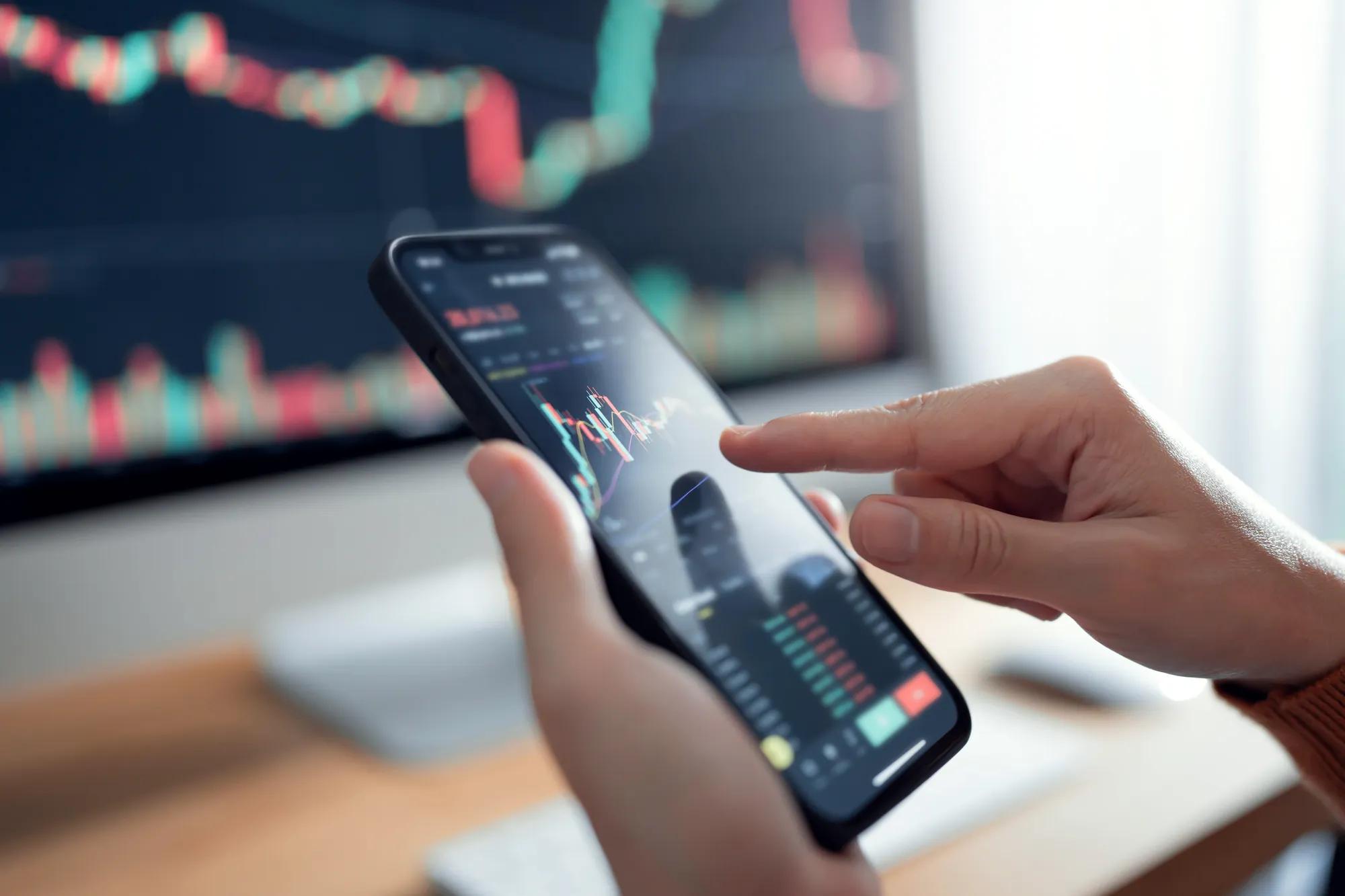 Closeup graph - Woman is checking Bitcoin price chart on digital exchange on smartphone, cryptocurrency future price action prediction.
