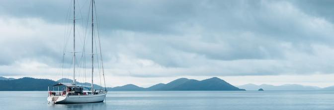 A sailing yacht on a moody blue day in the Whitsunday Islands, Queensland, Australia