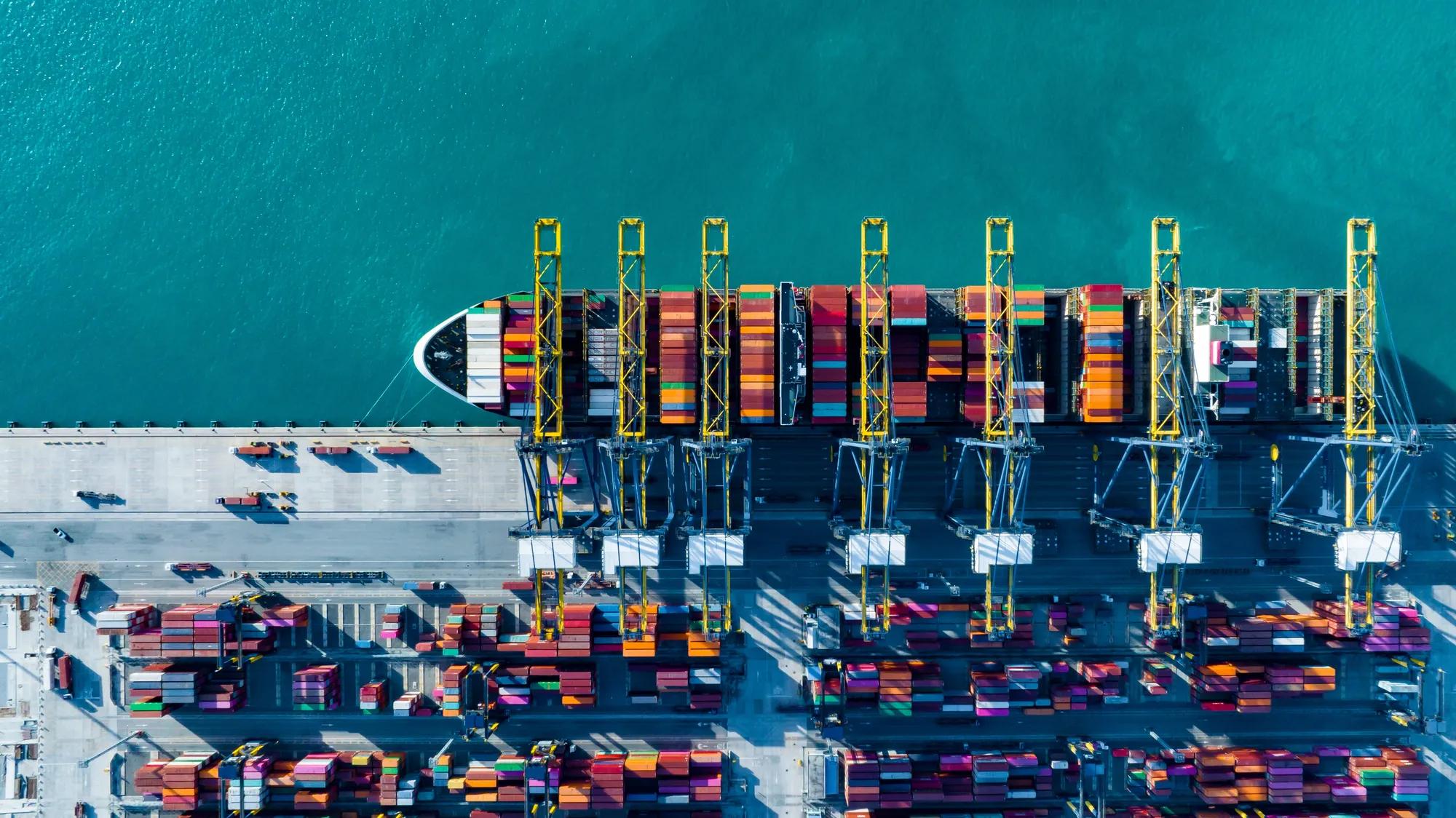 Aerial view over containers ship loading and unloading in sea port.Cargo ship import and export logistics business by container ship.Container loading cargo ship. Containers  transportation. 